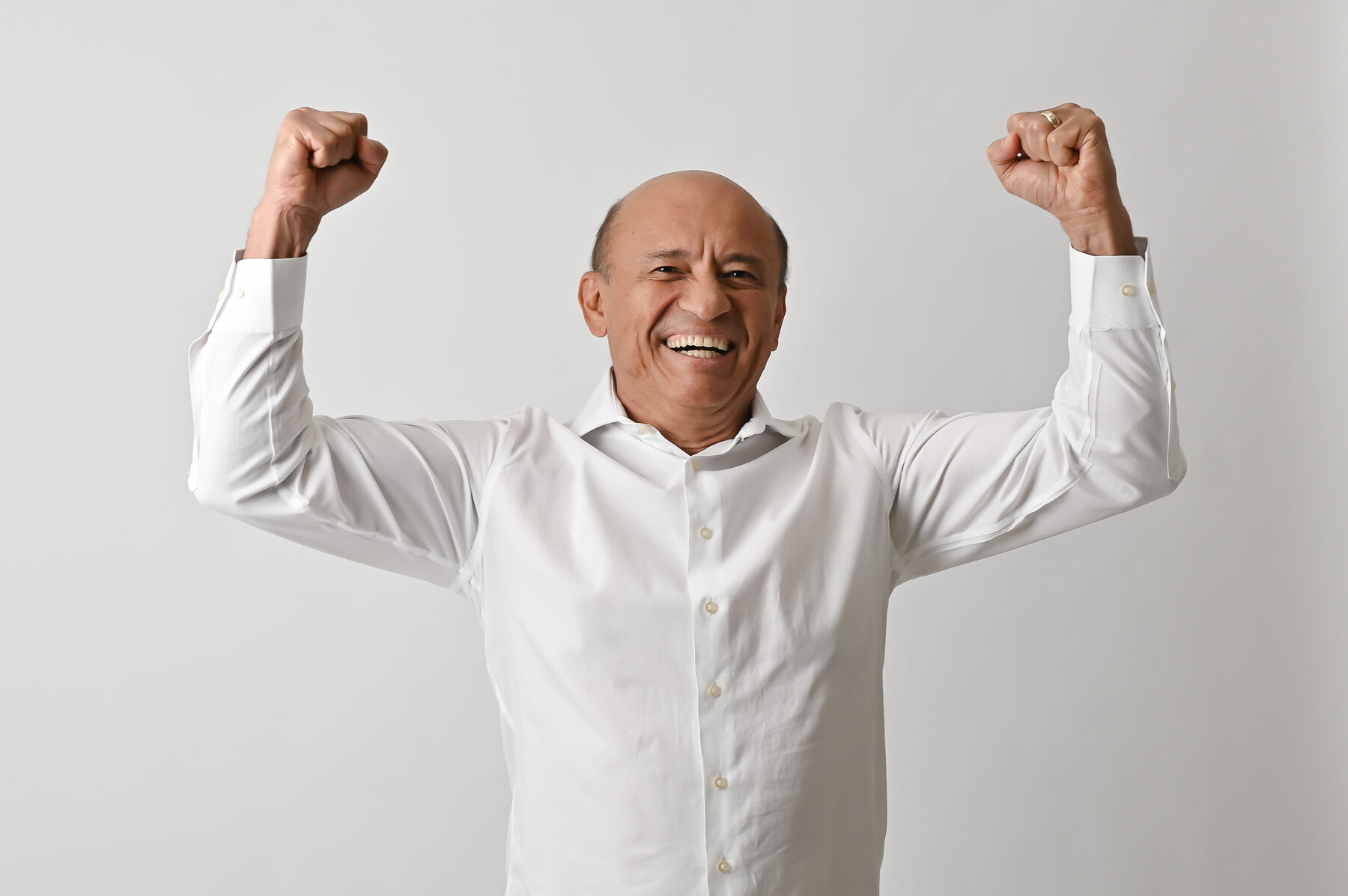 Livio Luciano sorrindo com os punhos erguidos