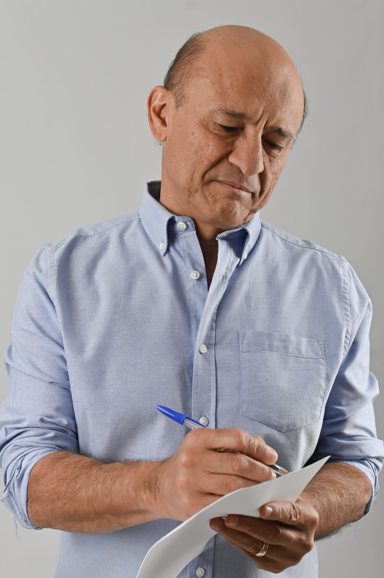 Livio Luciano fazendo anotações em uma folha de papel